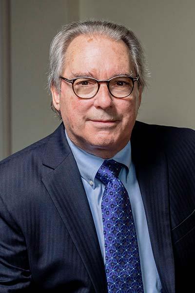Man wearing blue suite and tie with glasses