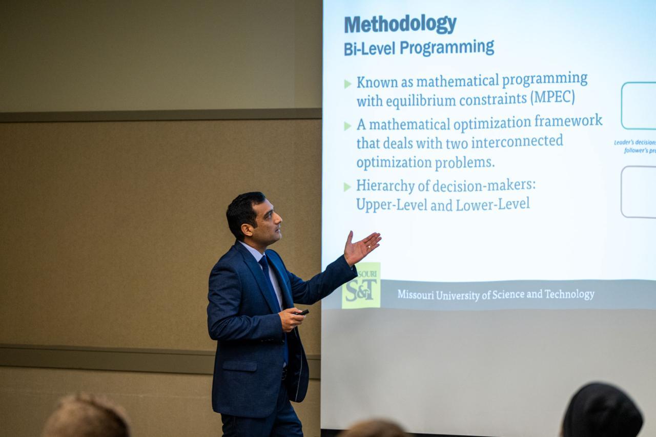 Students speaks in front of a group of people.